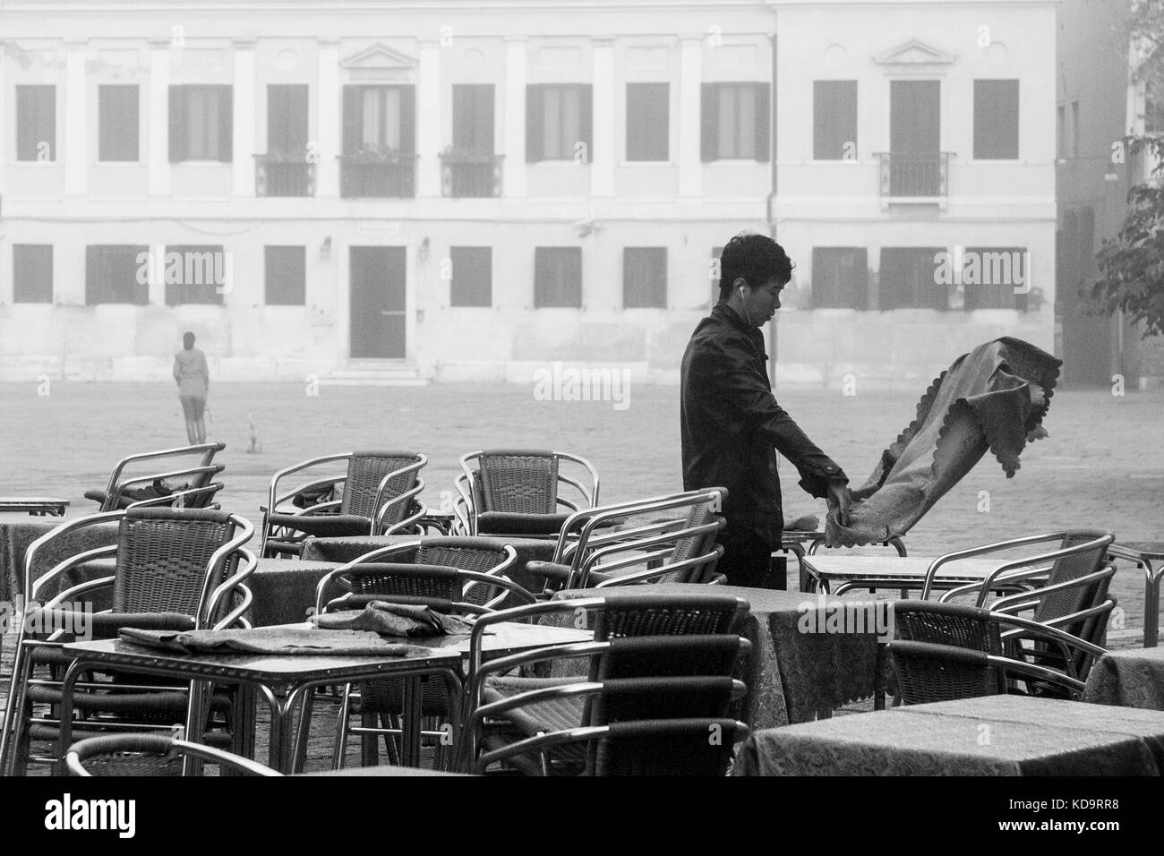 Venezia, Italia. 11 ottobre, 2017. (Foto è stata presa in bianco e nero) una lavoratori imposta i tavoli all'esterno durante una giornata di nebbia a venezia, Italia. in questo periodo a Venezia si avvia per la prima volta la nebbia di mattina. © Simone padovani / risveglio / alamy live news Foto Stock
