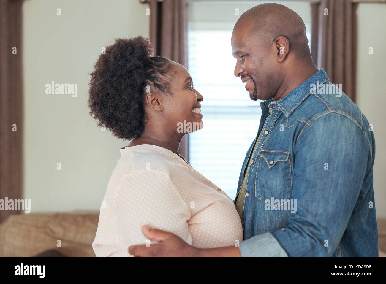 Affettuosa coppia africana in piedi a casa guardando ogni altro Foto Stock