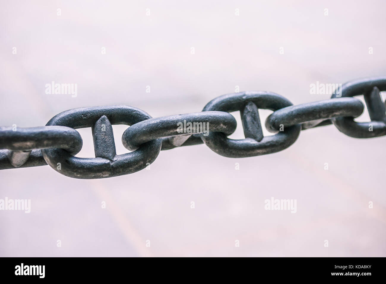 Close up di un arrugginito catena di ancoraggio su sfondo lucido Foto Stock