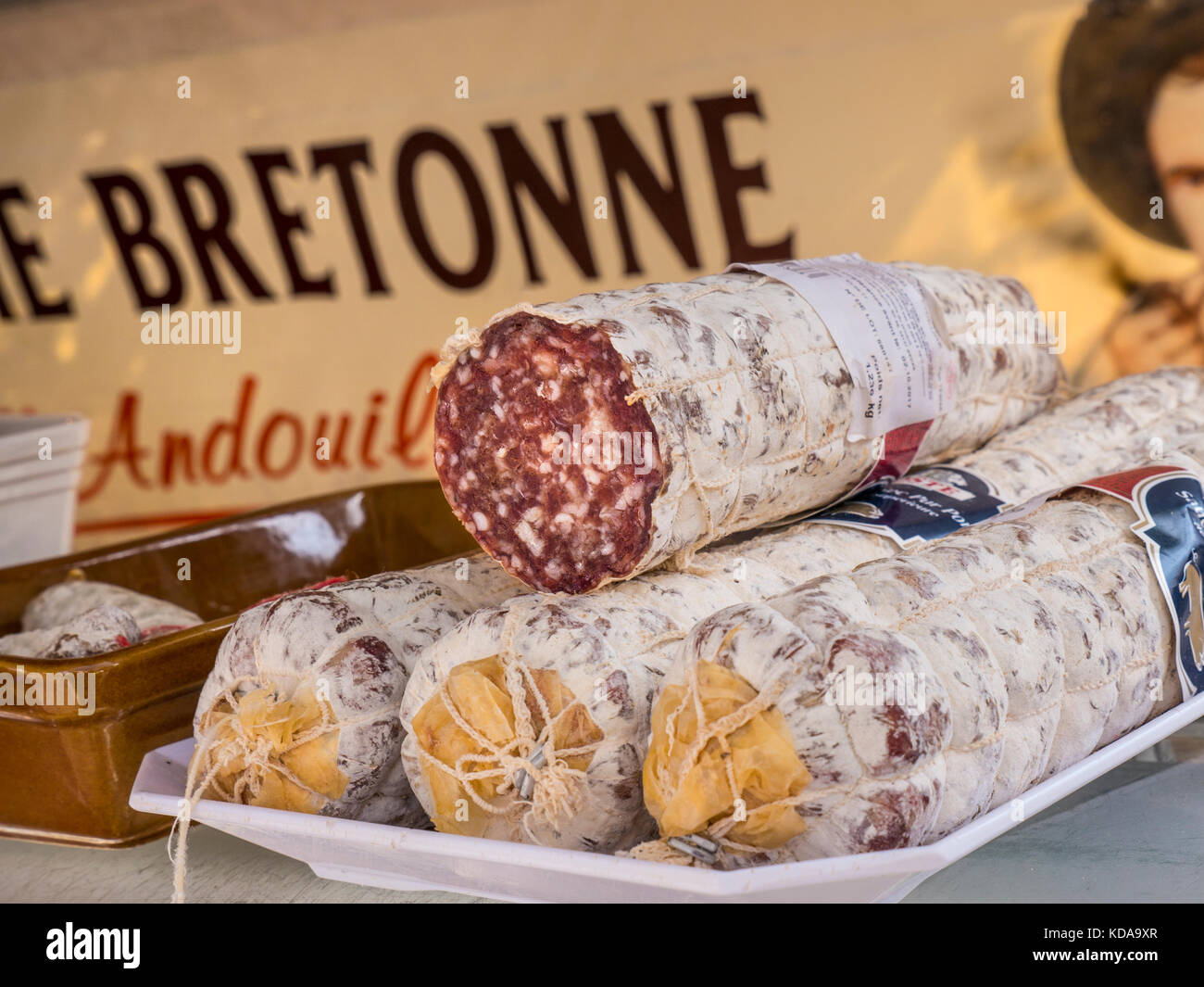 Saucisson, o 'saucisson sec,' una varietà di salsiccia francese densa e secca in esposizione per la vendita in un mercato agricolo francese bretone a Moëlan sur Mer Bretagna Francia Foto Stock