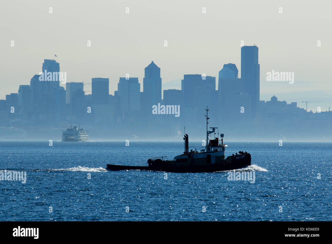 Il centro cittadino di Seattle con tug in fumo, Rockaway Beach Park, Bainbridge Island, Washington Foto Stock