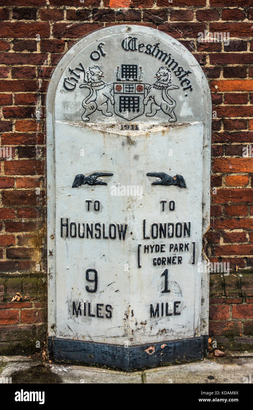 Old City of Westminster pietra miliare nella necessità di riverniciatura, che mostra la distanza da Hyde Park Corner e Hounslow, a Kensington, Londra, Inghilterra, Regno Unito. Foto Stock