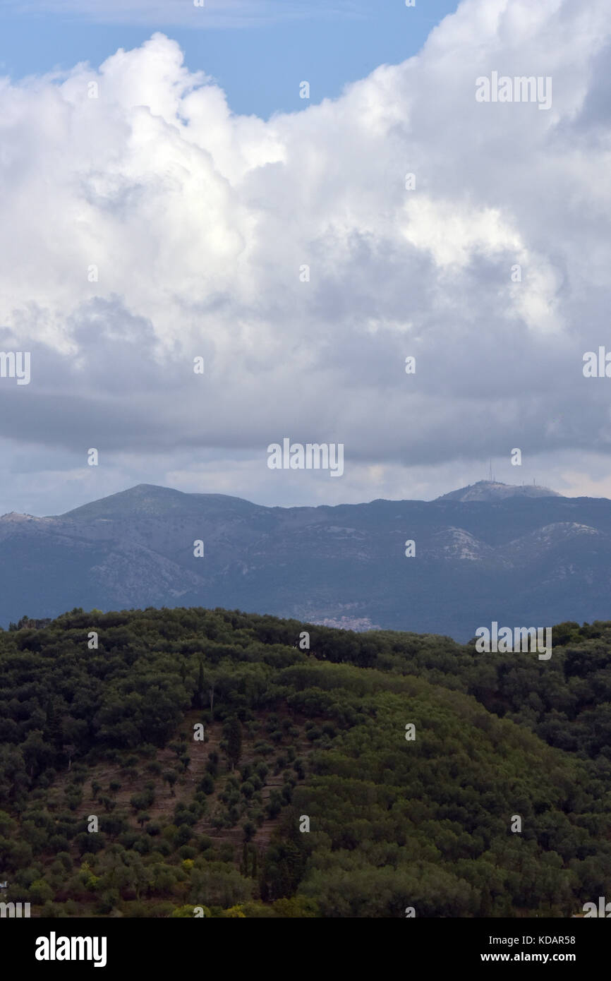Le montagne dell'Albania e della terraferma greca vista dalla costa di Corfù in un giorno nuvoloso dando la prospettiva aerea effetti di nebbia e haze. Foto Stock