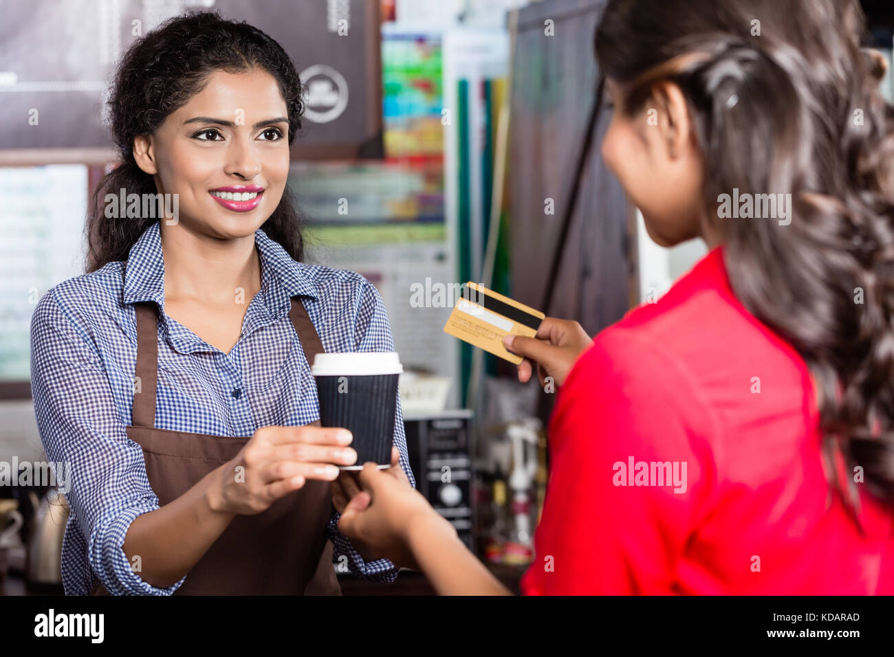 Femmina di pagamento del cliente per un caffè con carta di credito Foto Stock