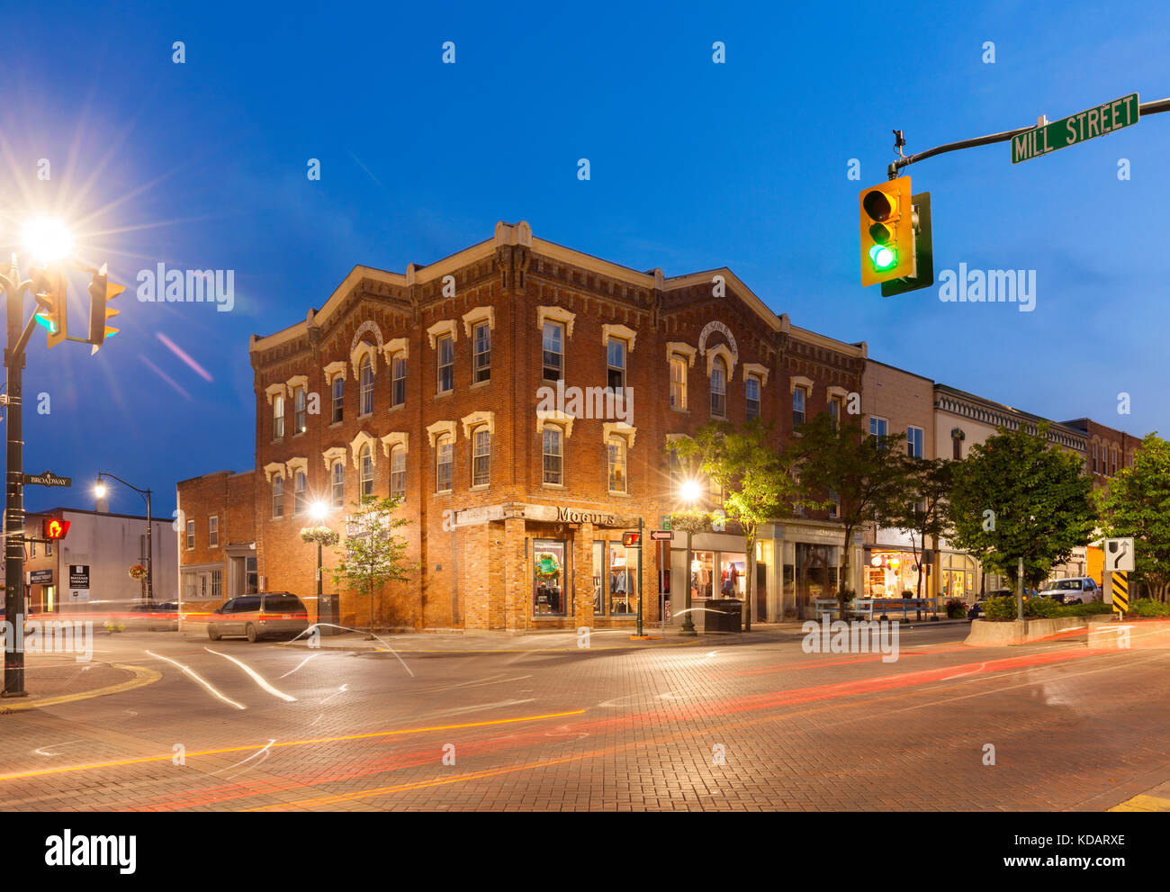 Un negozio di abbigliamento in un edificio storico all'angolo di Mill Street e Broadway al tramonto in downtown Orangeville, Ontario, Canada. Foto Stock