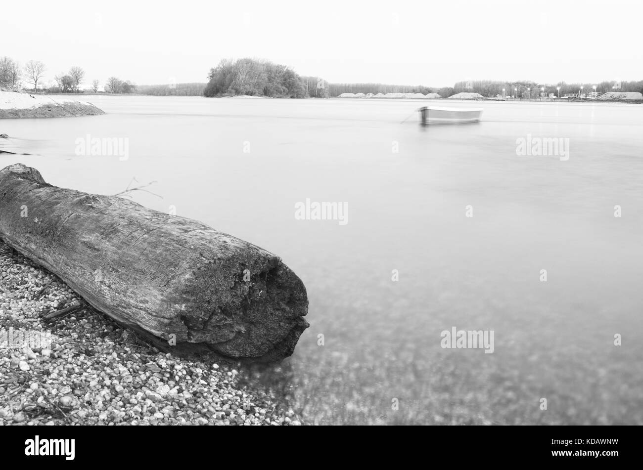 Driftwood log vuoto e barca sul fiume Danubio Foto Stock