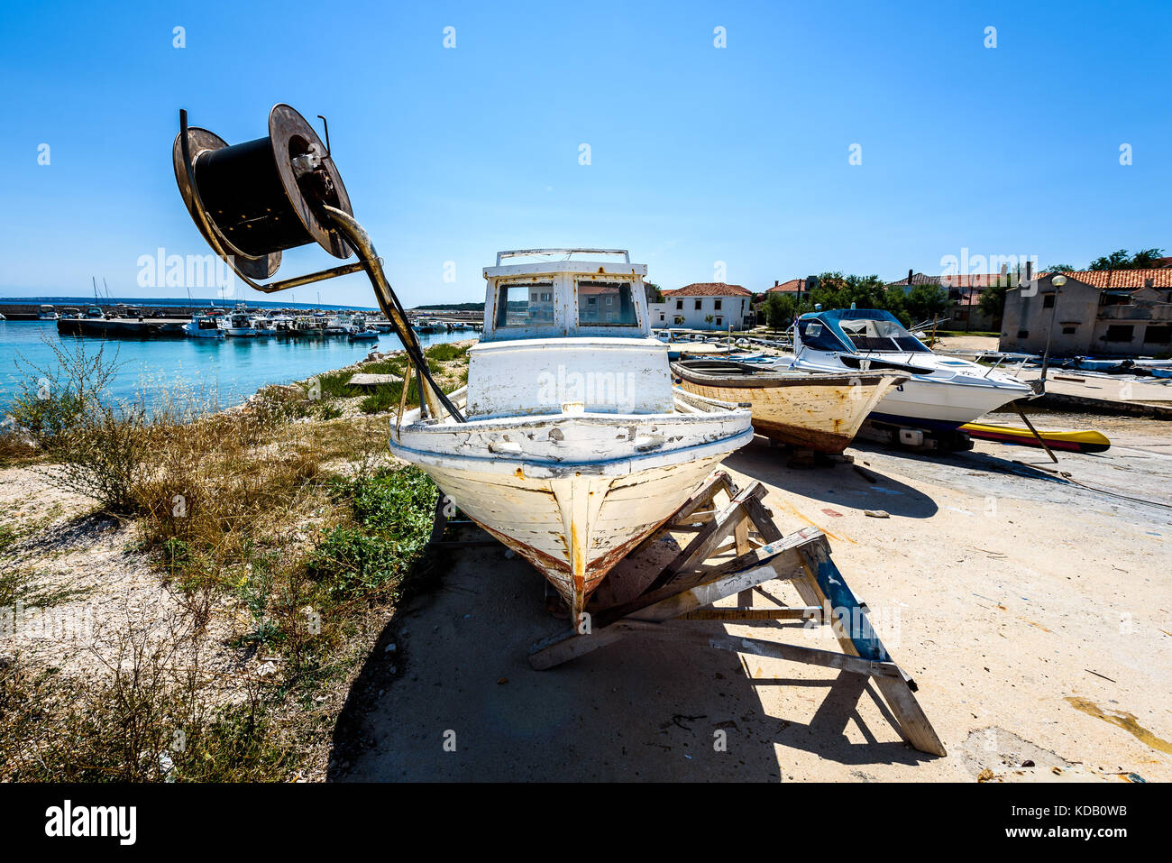 Riparazione e restauro di vecchi in legno nave da pesca o barca. vecchio weathered barca da pesca montata su martinetti in legno per il bacino di carenaggio riparazione e ristrutturazione con Foto Stock
