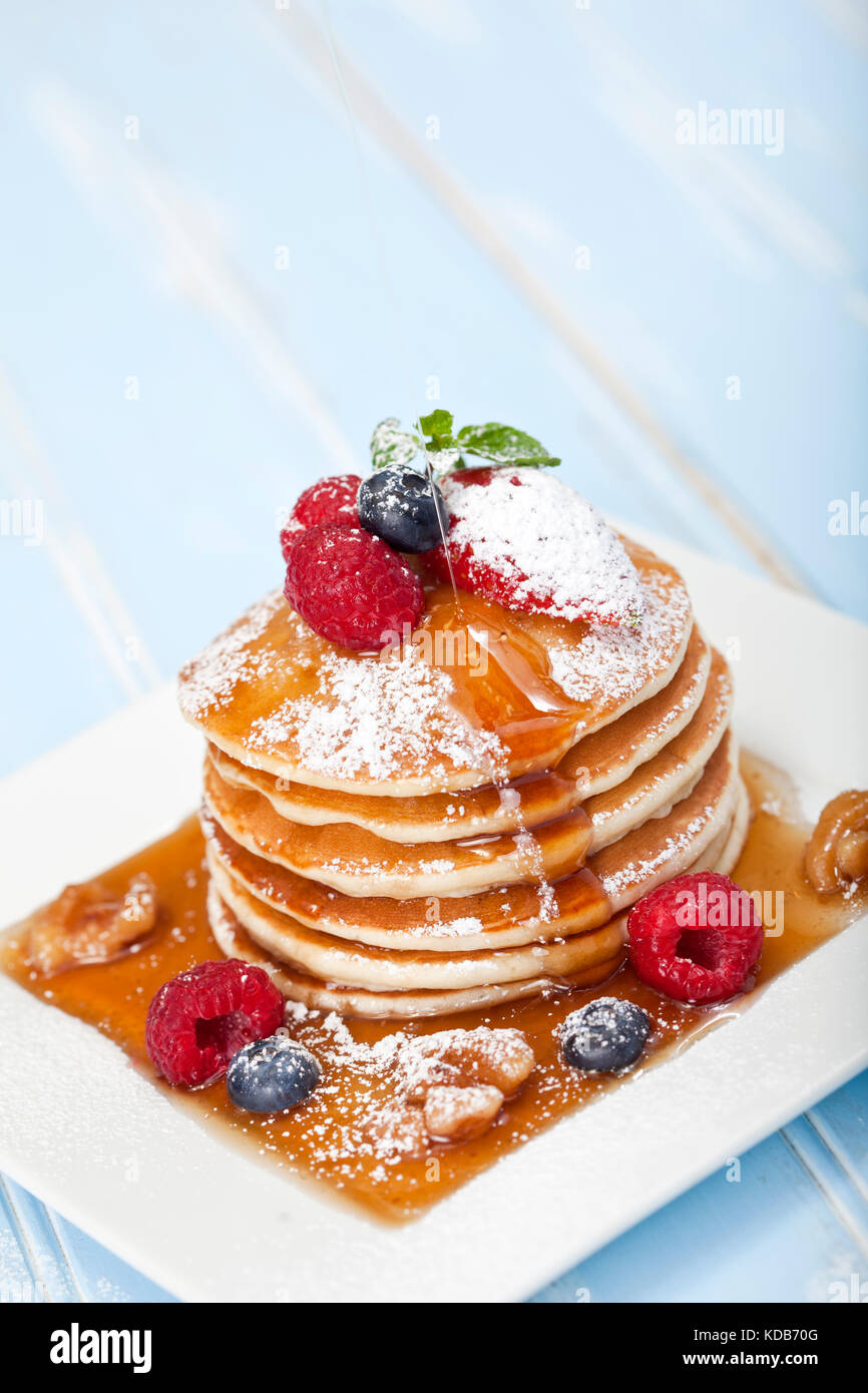 Pila di pancake con frutti di bosco e sciroppo d'acero Foto Stock