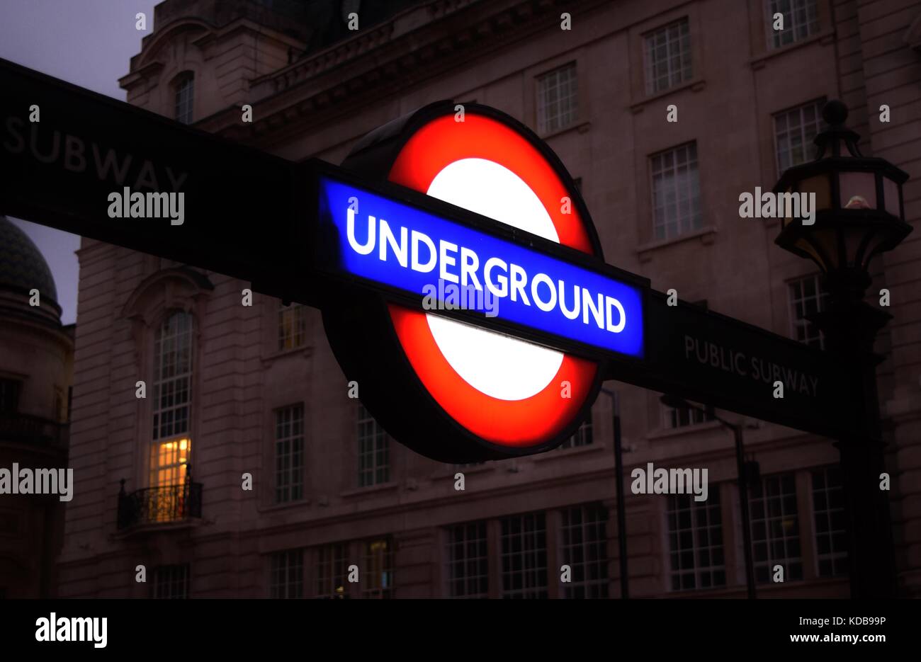 Un illuminato di firmare all'entrata di un metro di Londra, il tubo o la stazione della metropolitana - un simbolo di Londra del sistema di trasporto. Regno Unito, Gran Bretagna. Foto Stock