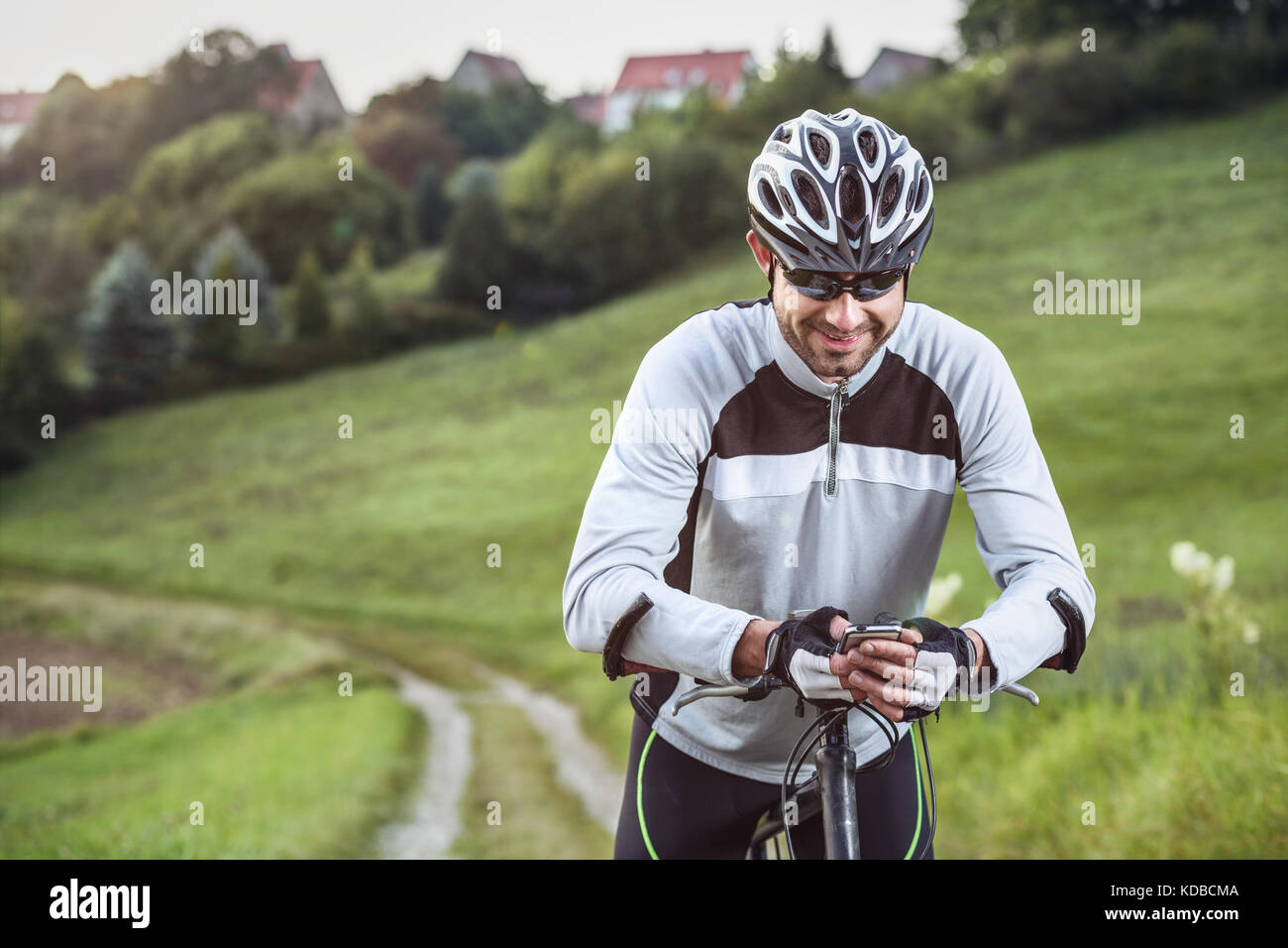 Ciclista tenendo un smartphone nelle sue mani Foto Stock