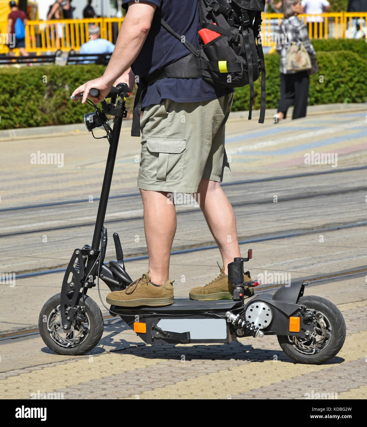 Un uomo su uno scooter elettrico sulla strada di città Foto Stock