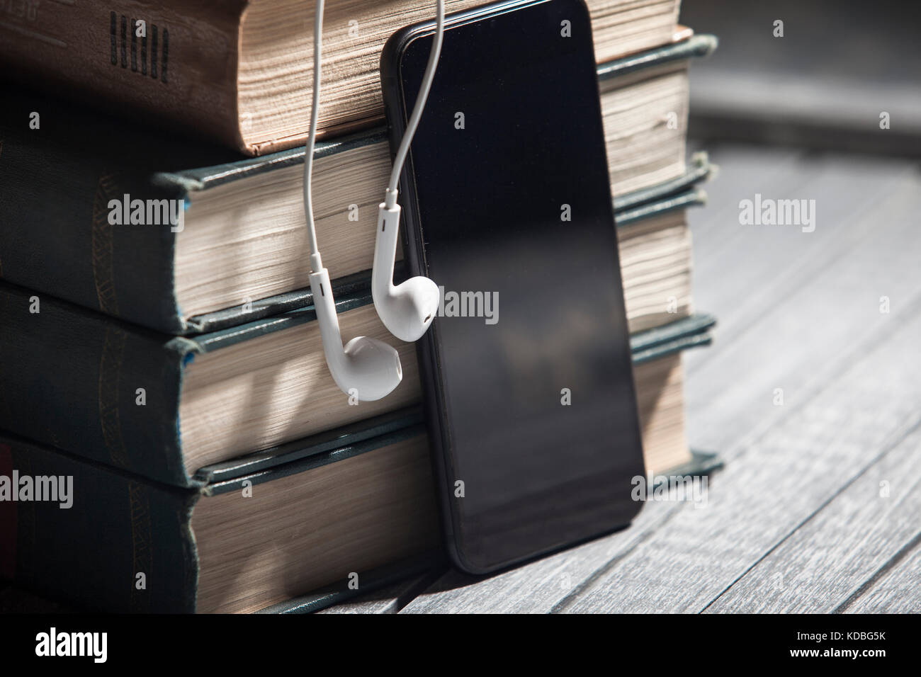 Il libro, gli auricolari di grandi dimensioni giacciono su un sfondo di  legno, audiolibri Foto stock - Alamy