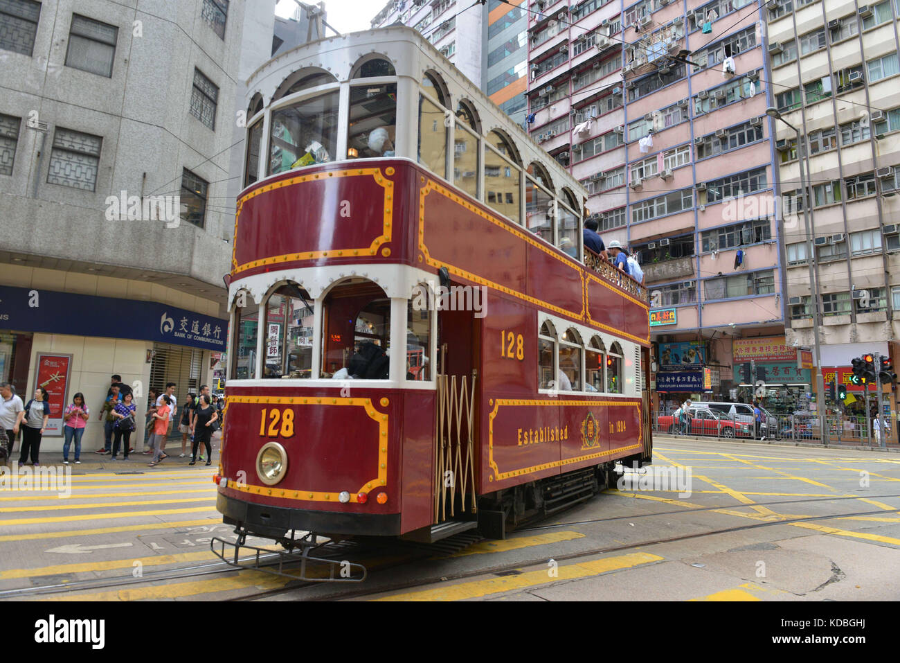 Nella parte inferiore degli edifici, colorato double-decker tram appartenenti ad Hong Kong Tramways con grandi annunci su suoi lati. Vecchio modello rinnovato e vernice Foto Stock