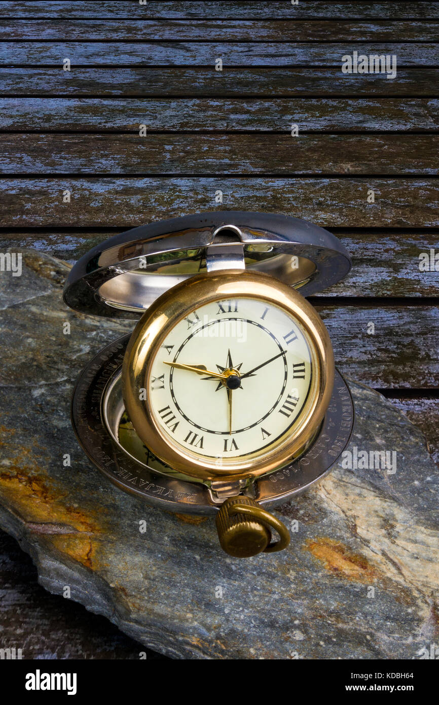 Tradizionale orologio in viaggio su un pezzo di ardesia su un tavolo di legno Foto Stock