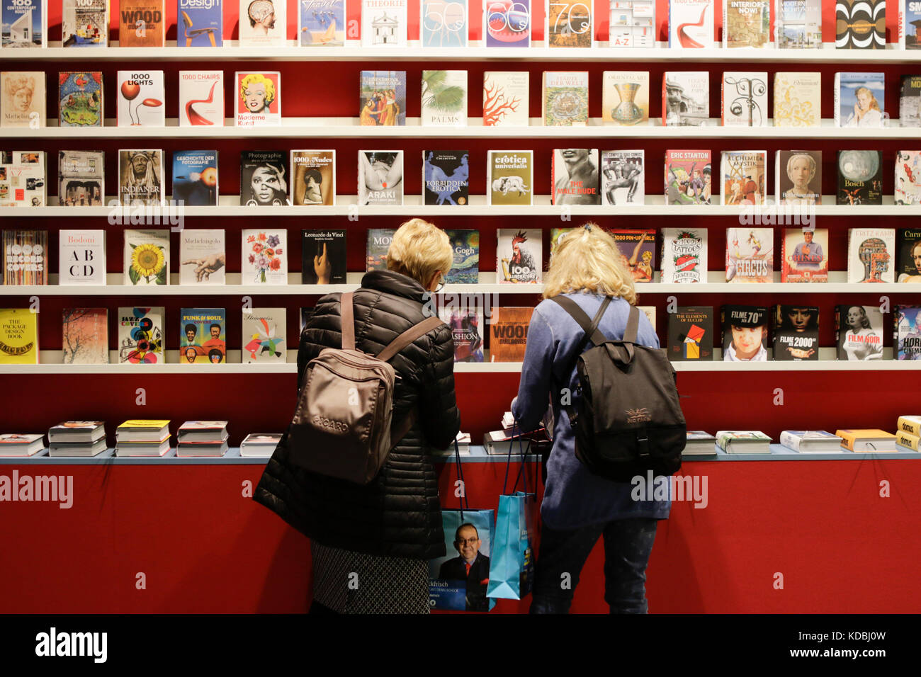 Francoforte, Germania. Undicesimo oct, 2017. I visitatori guarda i libri sugli scaffali con lo stand dell'editore tedesco taschen. fiera del libro di Francoforte 2017 è la più grande fiera del libro con più di 7.000 espositori e oltre 250.000 visitatori attesi. è aperto dal XI al XV ottobre con gli ultimi due giorni essendo aperto al pubblico in generale. Credito: Michael debets/Pacific press/alamy live news Foto Stock