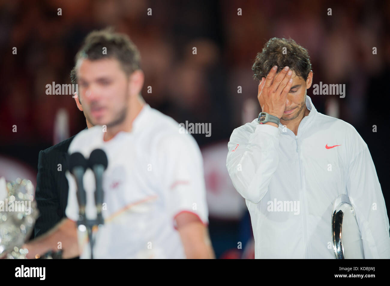 Rafael Nadal strappa le lacrime dopo aver perso l'Australian Open di Stanislaus Wawrinka mentre Wawrinka fa il suo discorso di vittoria. Wawrinka della Svizzera de Foto Stock