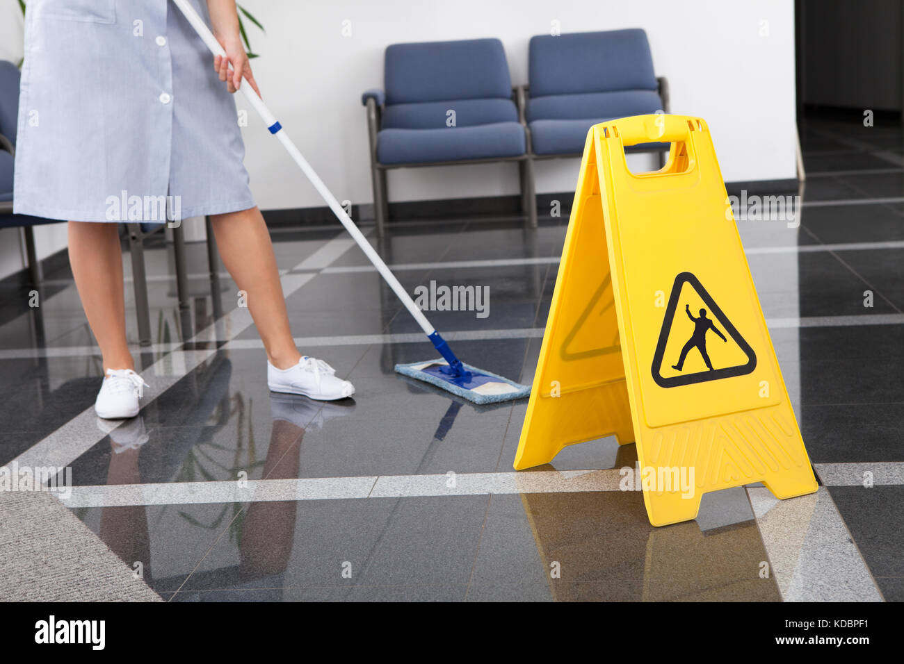 Cameriera la pulizia del pavimento con mop in ufficio Foto Stock