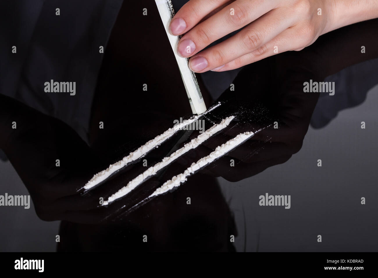 Close-up di persona lo sniffing cocaina farmaci con laminati nota banca Foto Stock