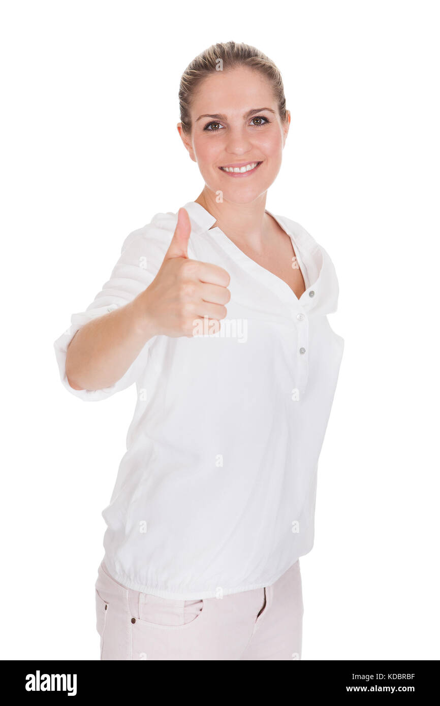 Giovane donna gesticolando pollice in alto segno su sfondo bianco Foto Stock