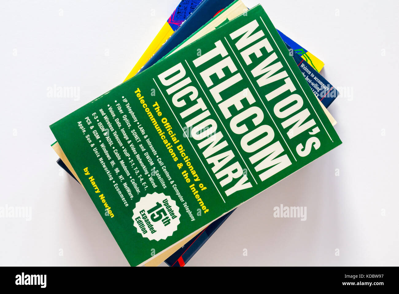 Pila di libri con Newton Telecom dizionario, il dizionario ufficiale di Telecomunicazioni & Internet prenota sulla parte superiore impostato su sfondo bianco Foto Stock