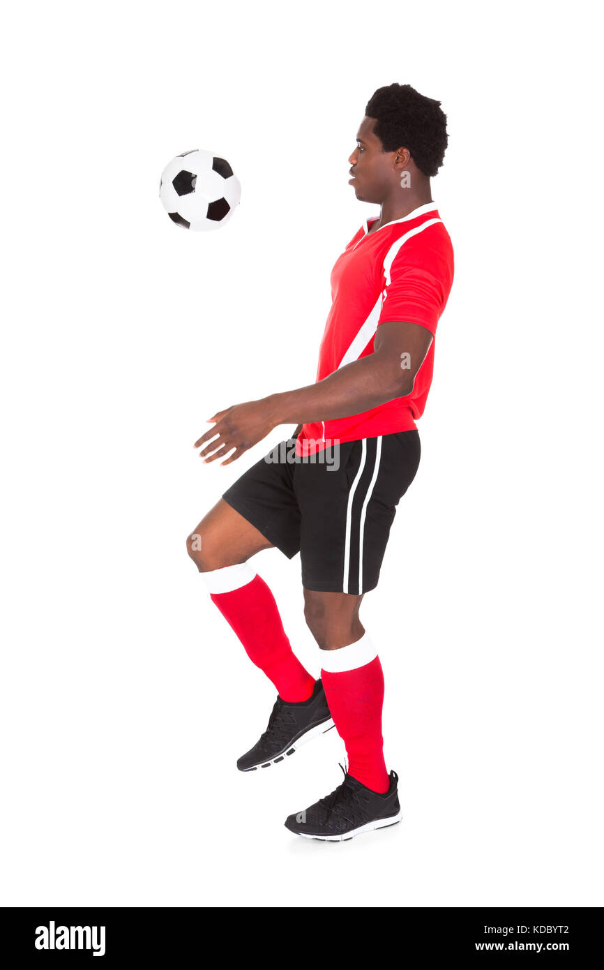 Ritratto di African giocatore di calcio calcio calci su sfondo bianco Foto Stock