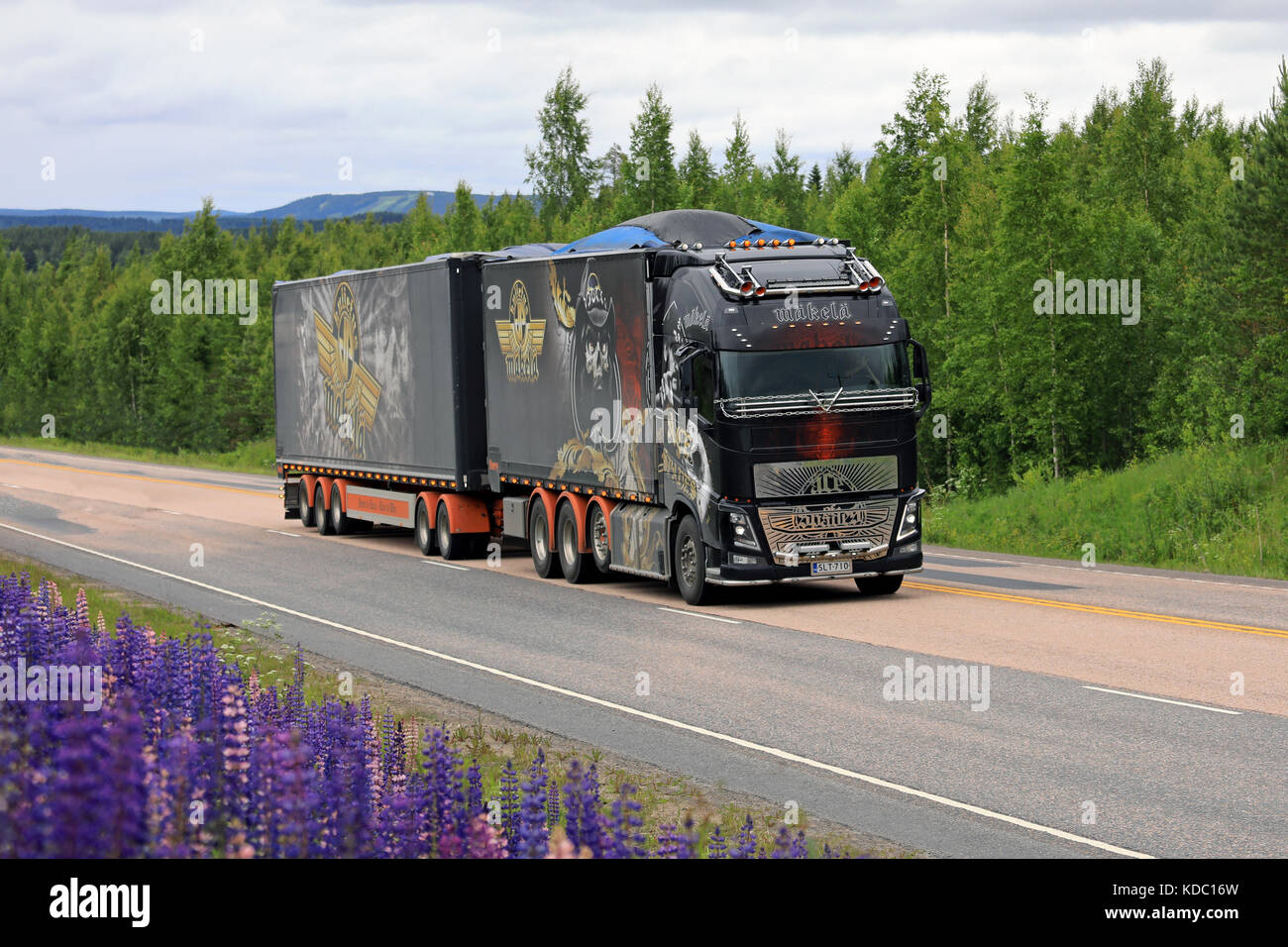 JAMSA, FINLANDIA - 6 LUGLIO 2017: Lo show truck Volvo FH16 Ace of Spades si sposta lungo la strada panoramica della Finlandia centrale sotto il cielo oscuro coperto A. Foto Stock