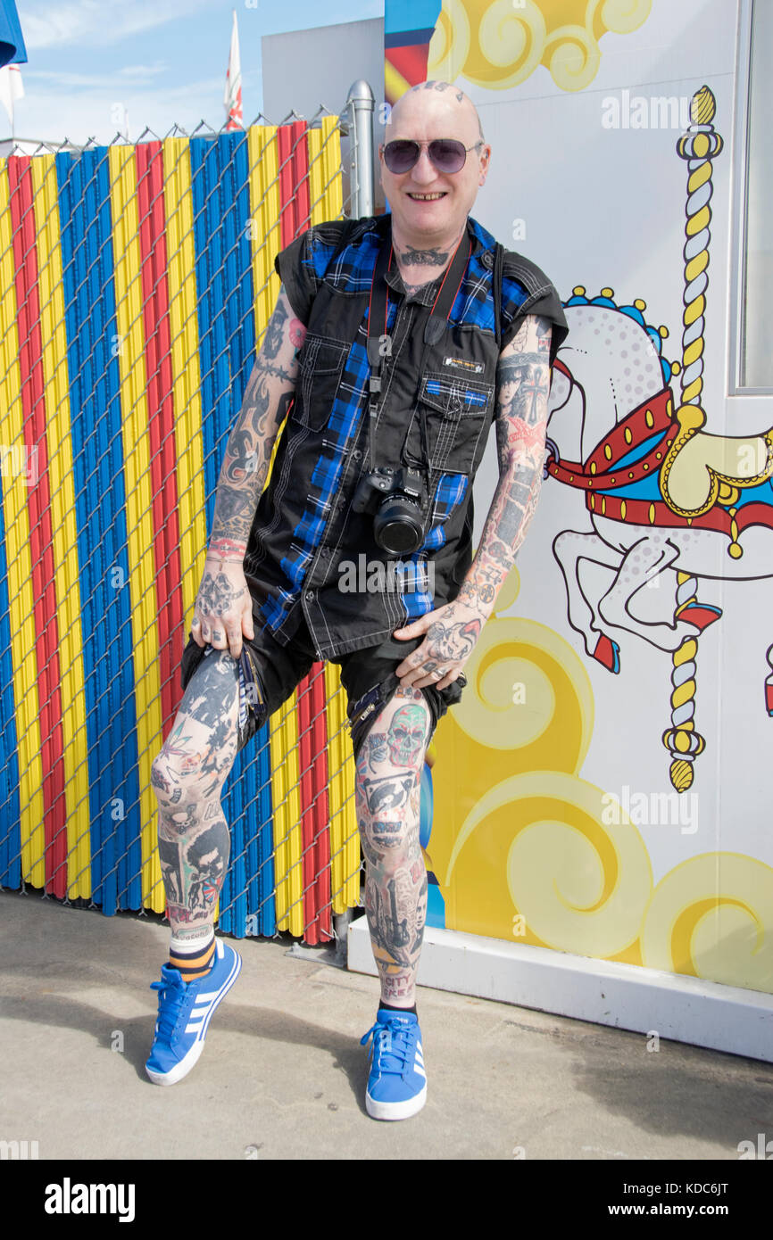 Un turista britannico da Newcastle ricoperti di tatuaggi e visitare il lungomare di Coney Island Brooklyn, New York City. Foto Stock