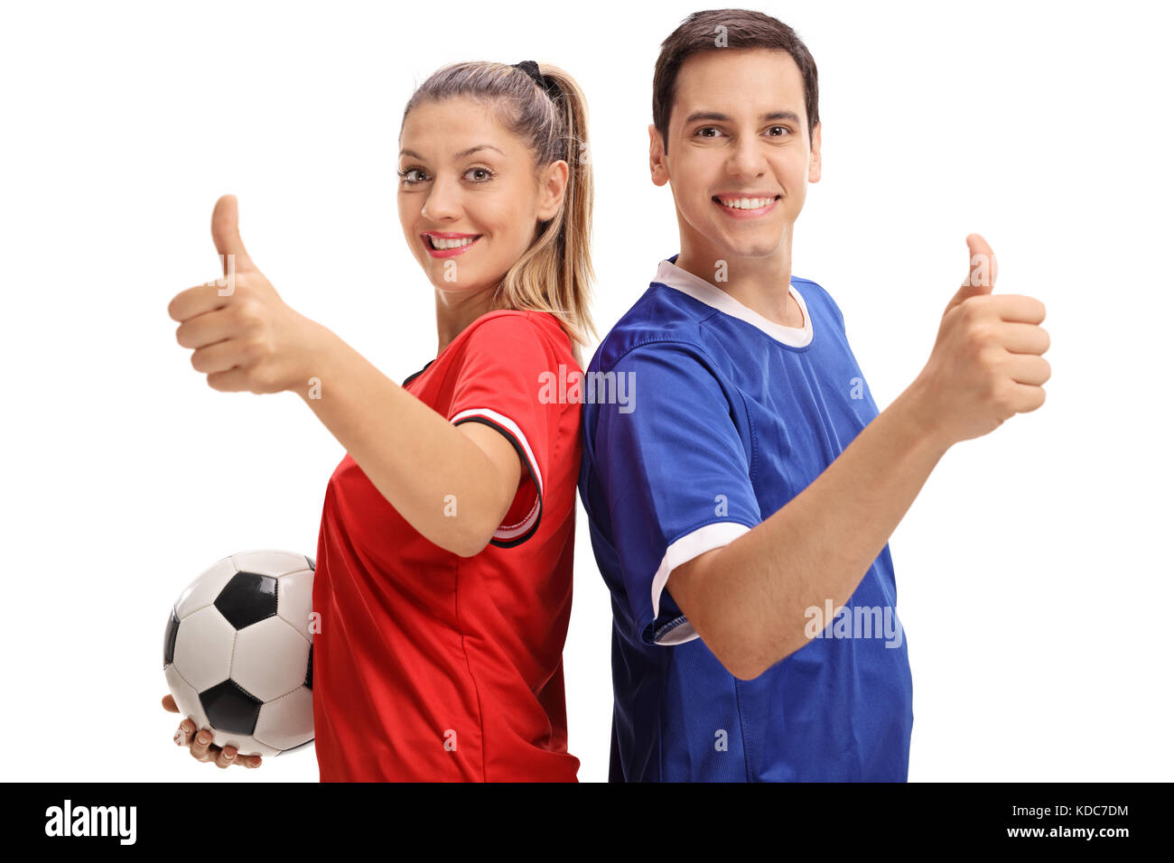 Femmina e un maschio di giocatore di calcio mantenendo le loro pollice in alto e sorridente isolati su sfondo bianco Foto Stock