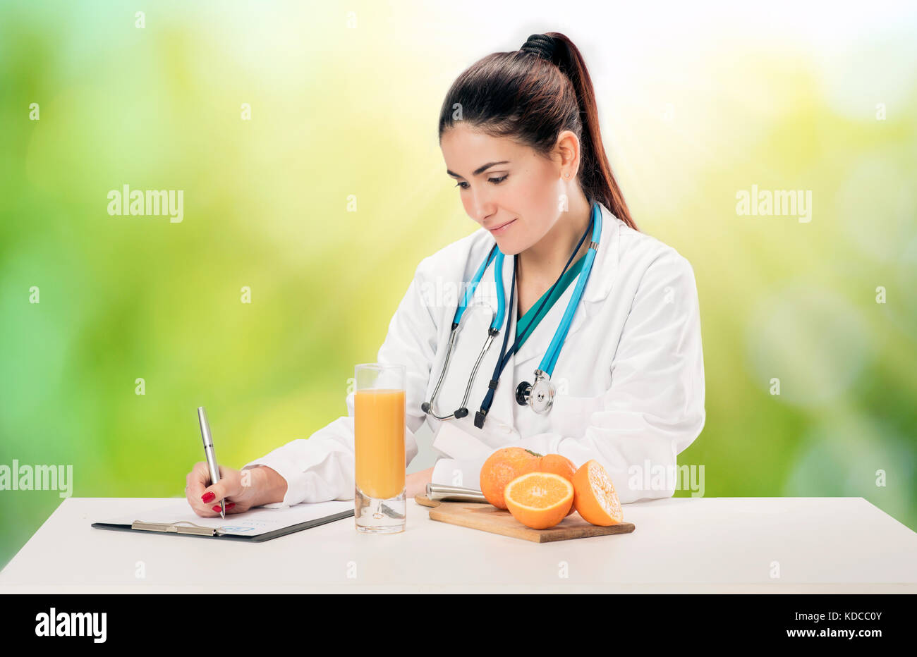 Nutrizionista scrivere i record medici e ricette con arance fresche e succhi di frutta Foto Stock
