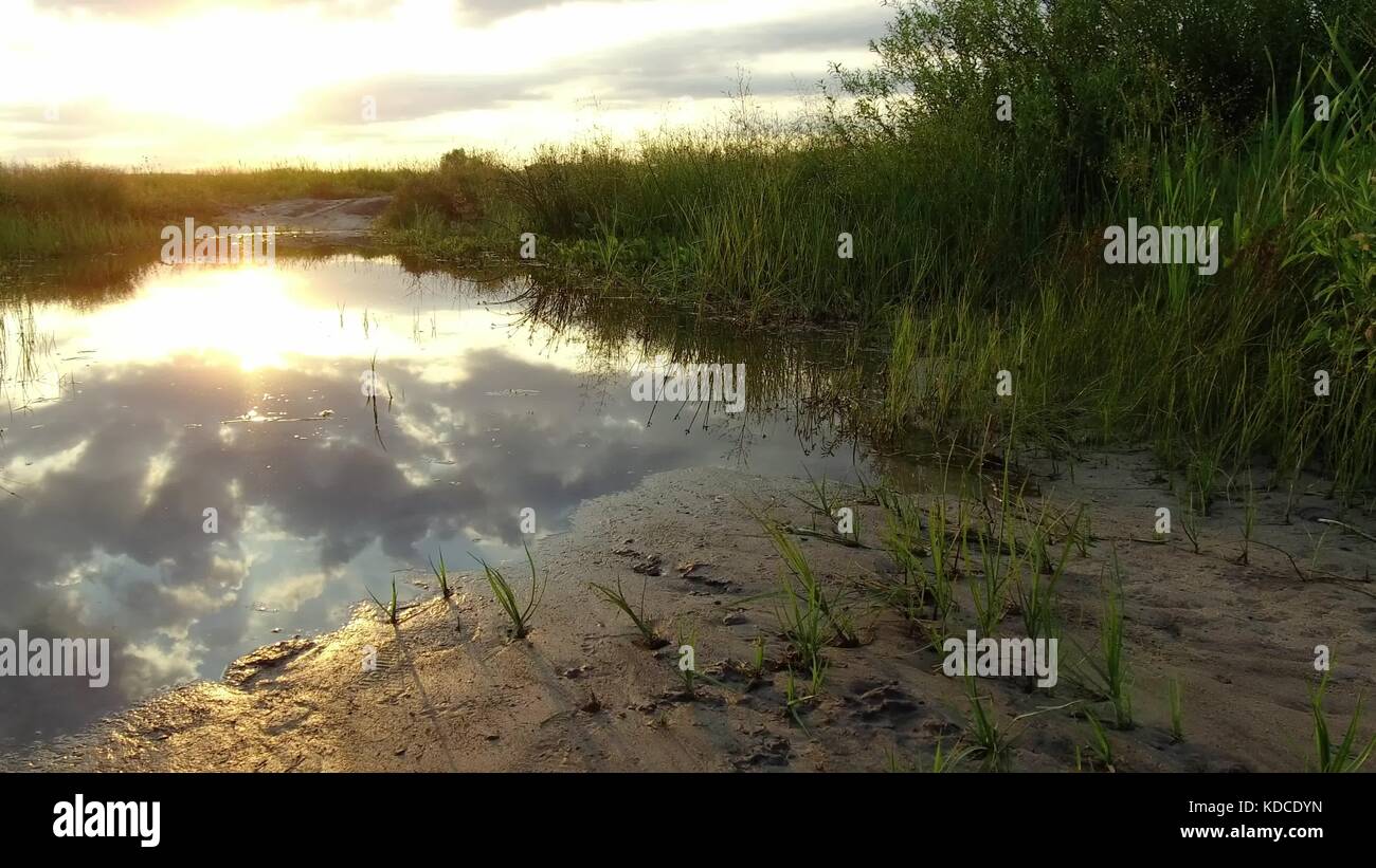 Natura lago di riflessione di nuvole nell'acqua luce del sole al tramonto Foto Stock