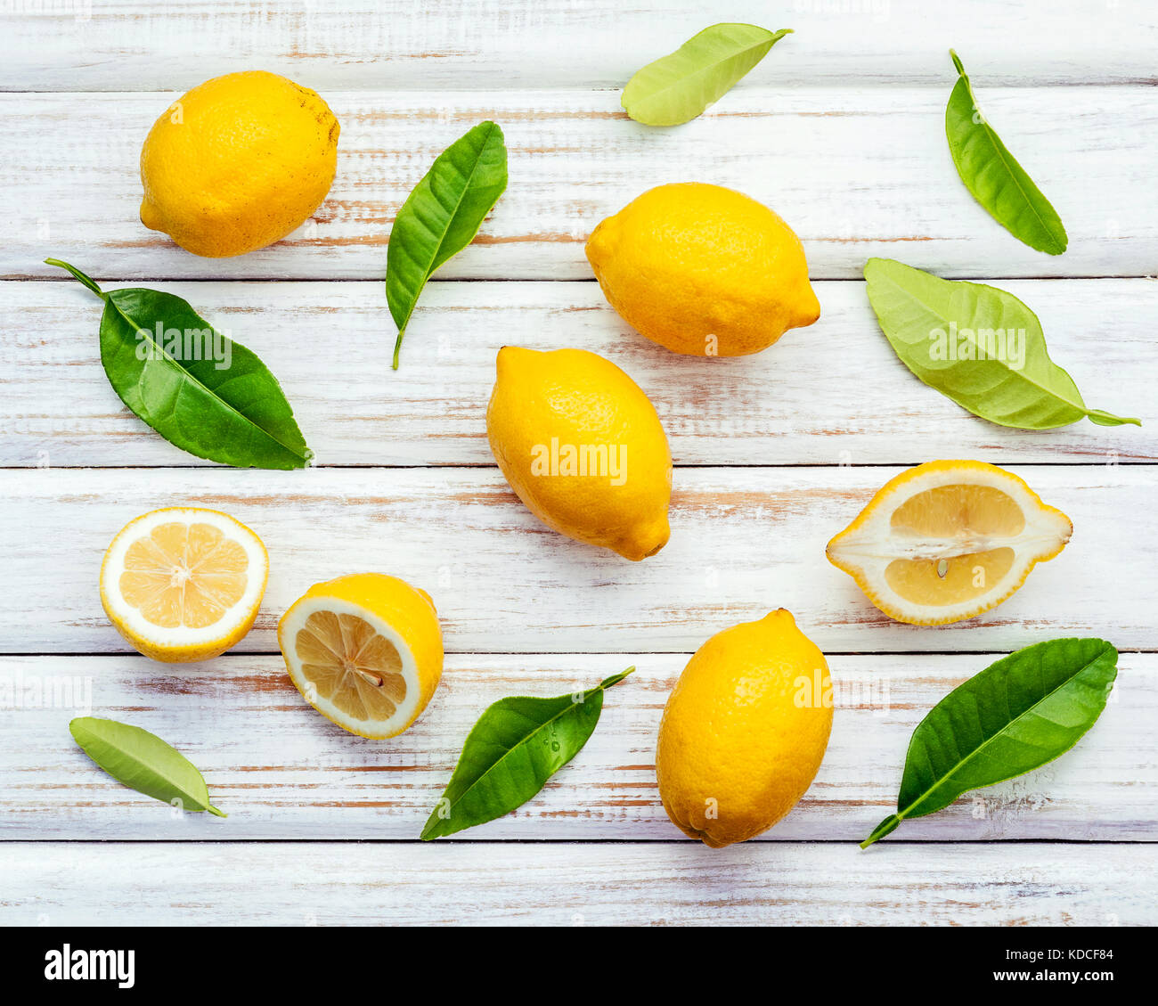 Limoni freschi Limoni e foglie sul legno rustico sfondo. limoni freschi e  la fetta di limone su un tavolo di legno con piatto laici. agrumi freschi  backgroun Foto stock - Alamy