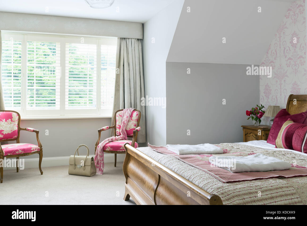Una camera confortevole in una tipica casa del Regno Unito. mostra sedie stile ucciderà bed & finestre con persiane. Foto Stock