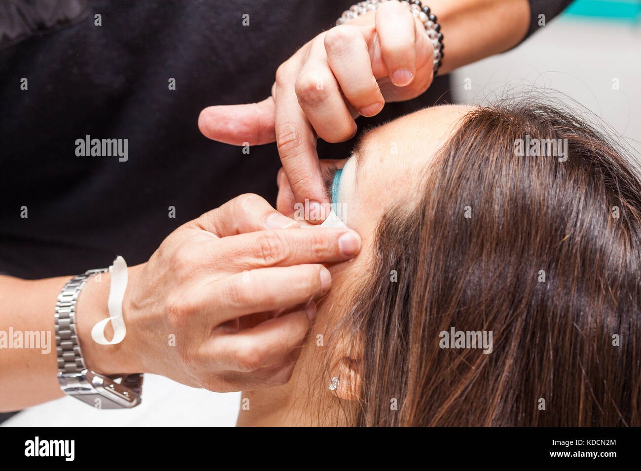 Make up Artist usando del nastro adesivo protettivo per la creazione di occhi di gatto Foto Stock