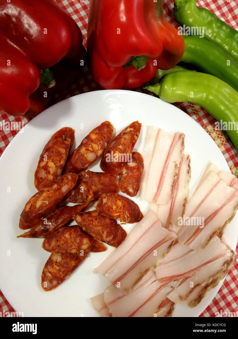 Fette di gustosi piatti salati pancetta, salsicce e verdure Foto Stock