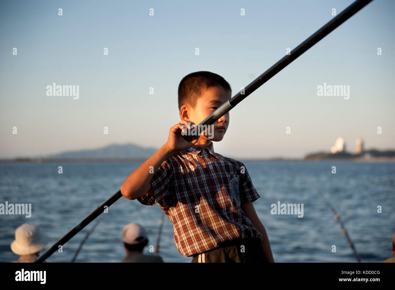 Les enfants sont toujours au rendez-vous lorsque les pêcheurs viennent en fin d'après midi le long du port de Wonsan. Wonsan se trouve au bord de la m Foto Stock