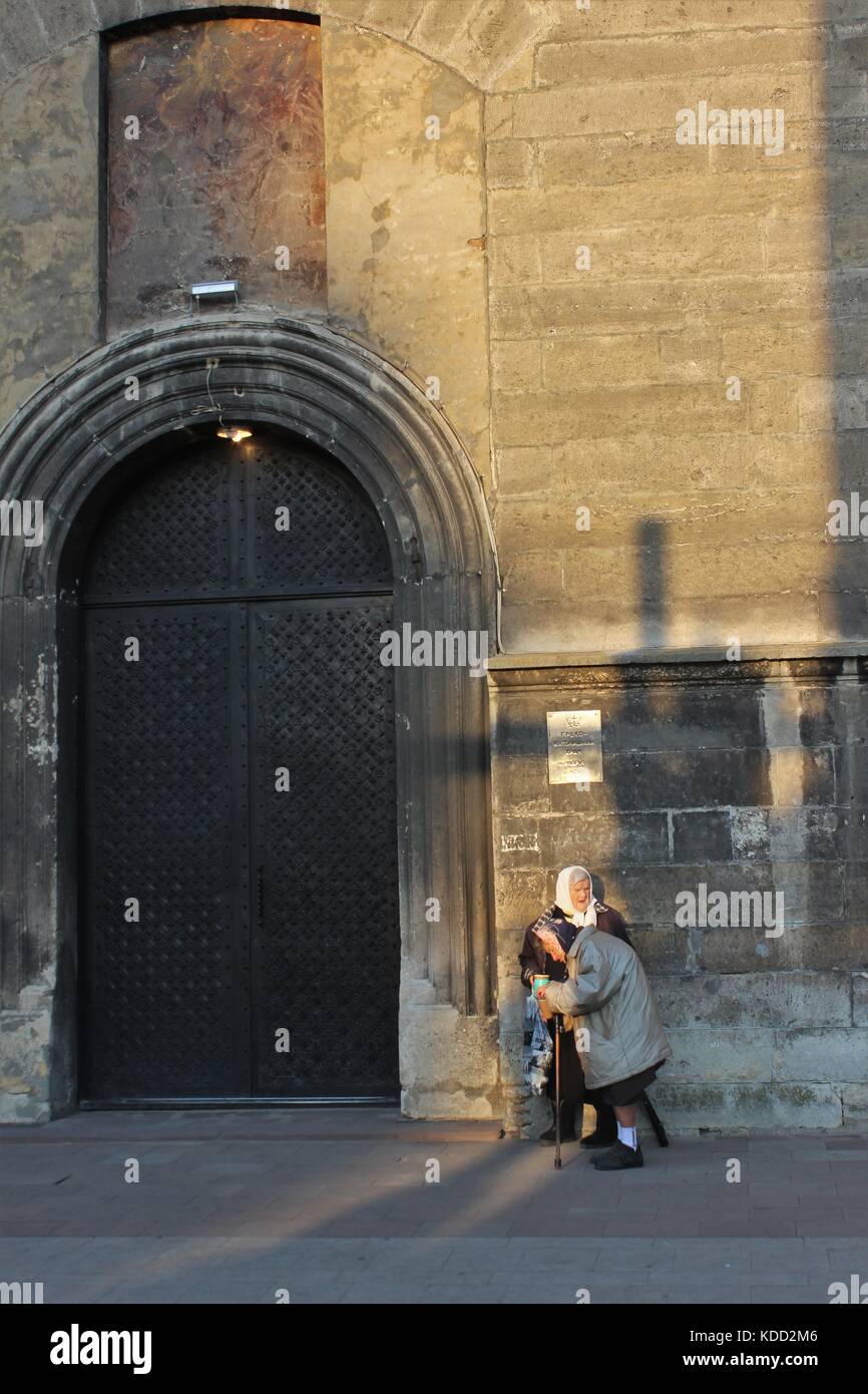Due anziane signore di accattonaggio accanto ad una chiesa di Lviv, Ucraina Foto Stock