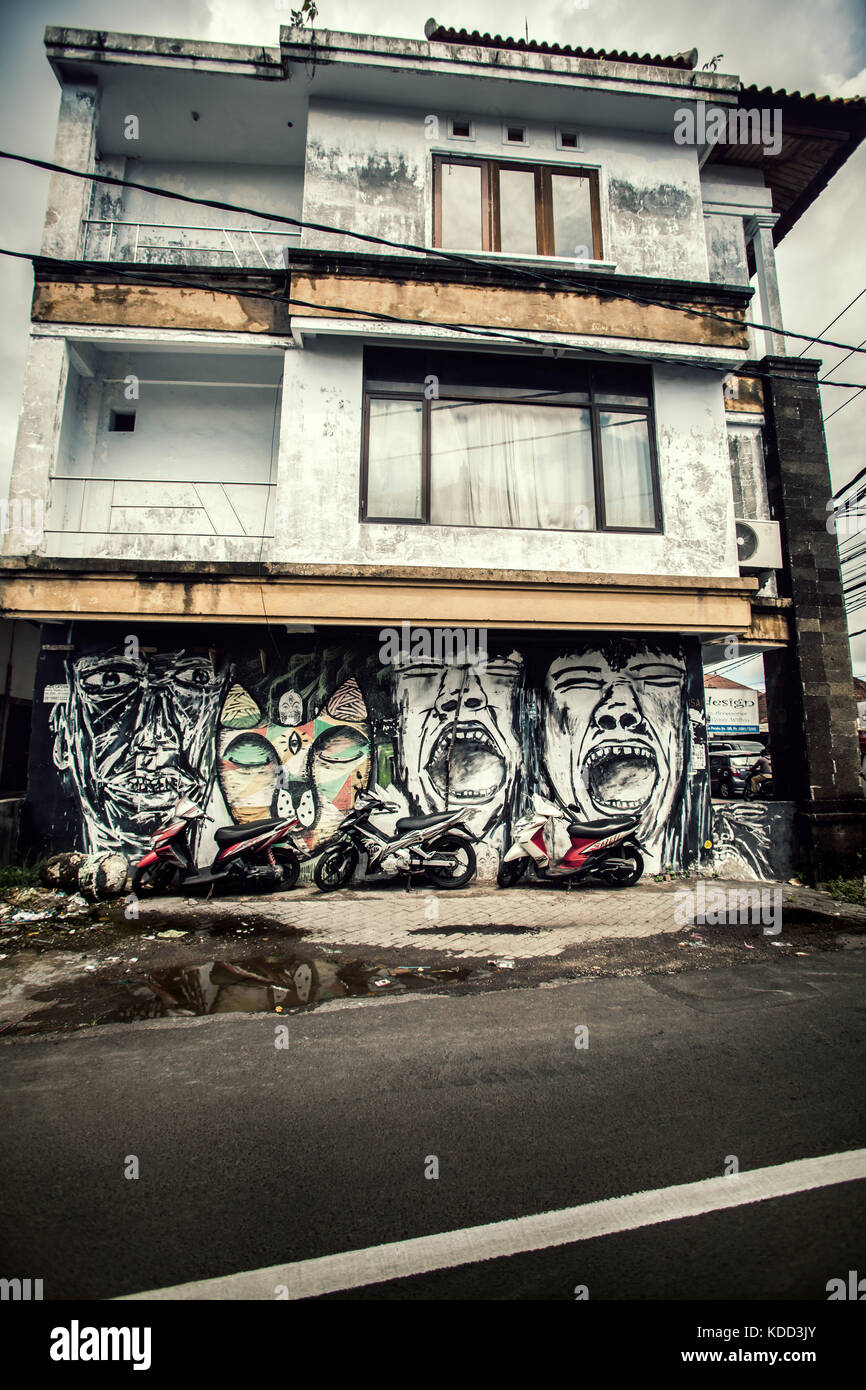 Edificio residenziale a Bali che mostra tutti i segni di abbandono con gigantesche facce graffiti che ornano le pareti e segni generali di costruzione disrepaired Foto Stock