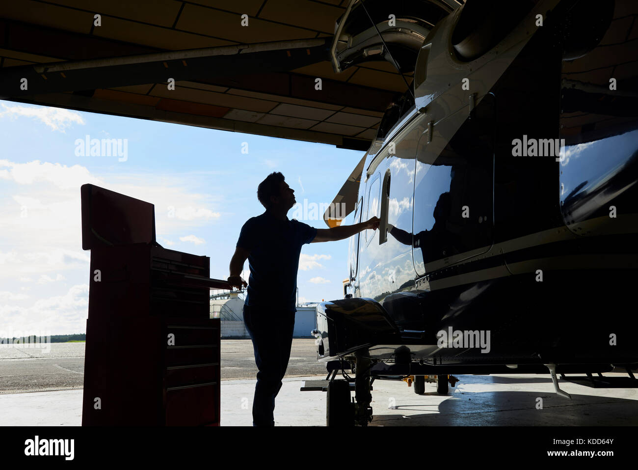 Silhouette di aero maschio ingegnere in elicottero in hangar Foto Stock