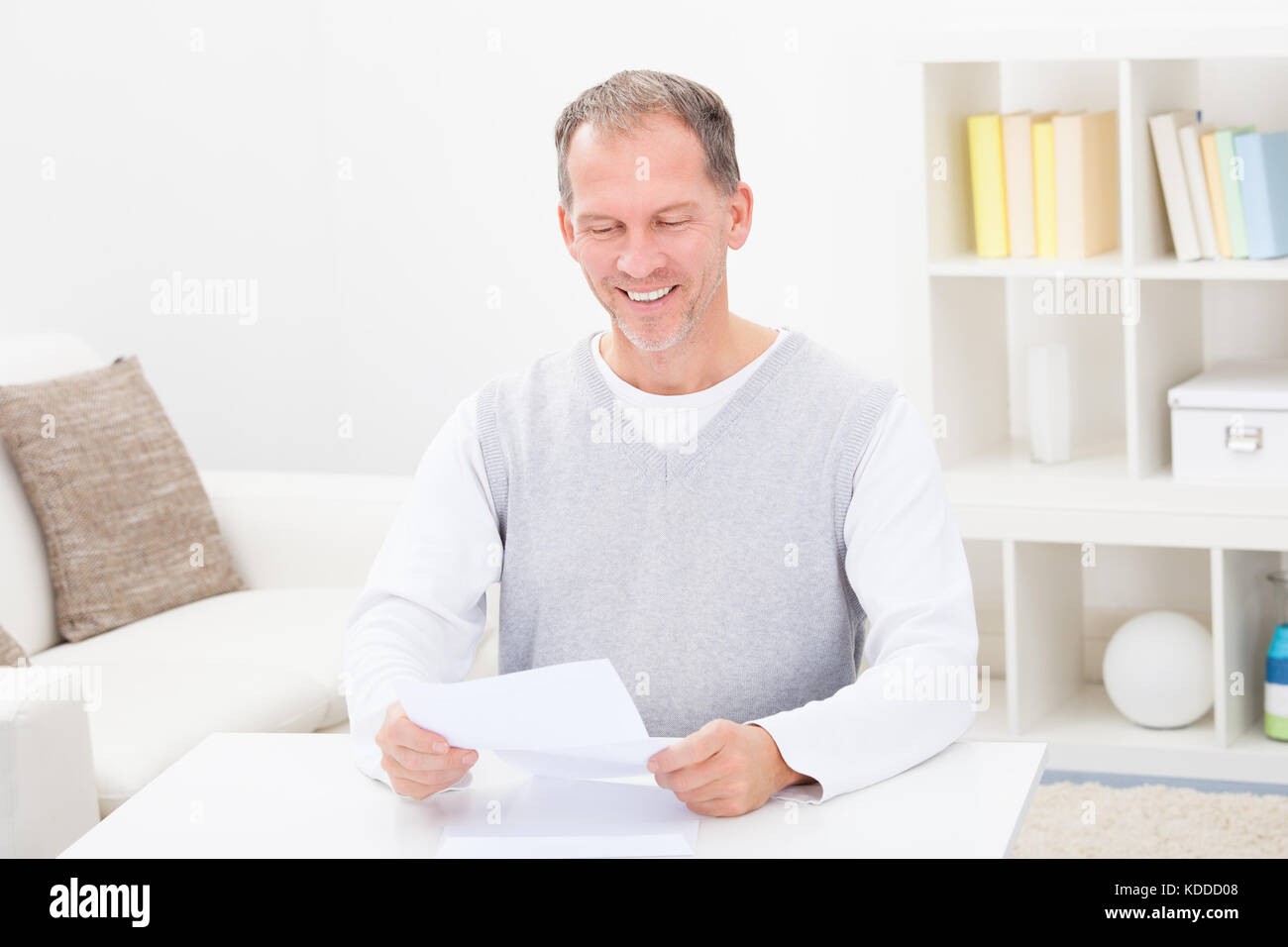 Felice uomo maturo Azienda Documento a casa Foto Stock