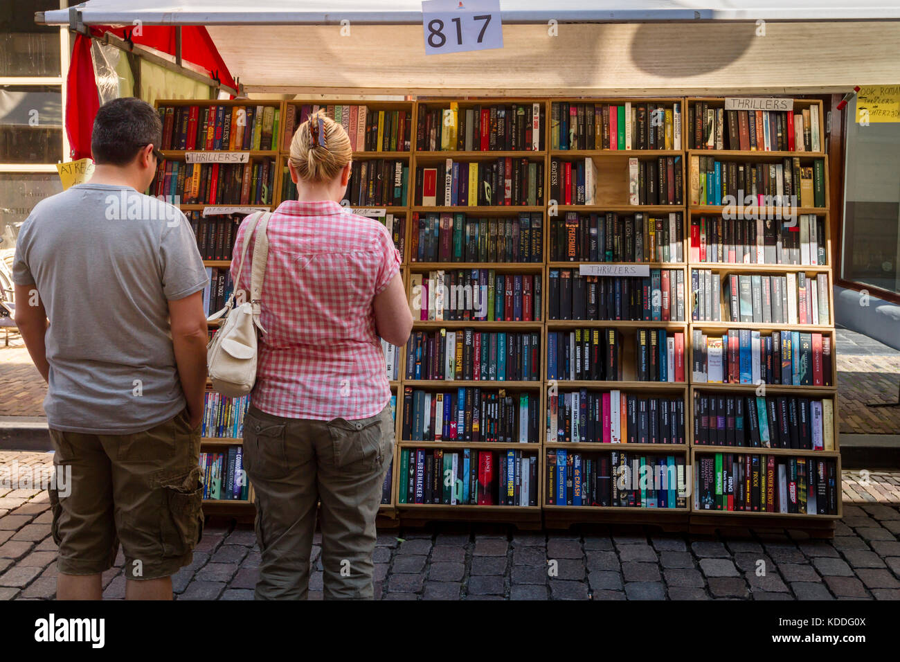 Dordrecht, Paesi Bassi - 7 luglio 2013: matura in piedi in un libro in stallo decidere cosa acquistare presso il libro annuale mercato detenuto nel centro di Dordrecht. Foto Stock