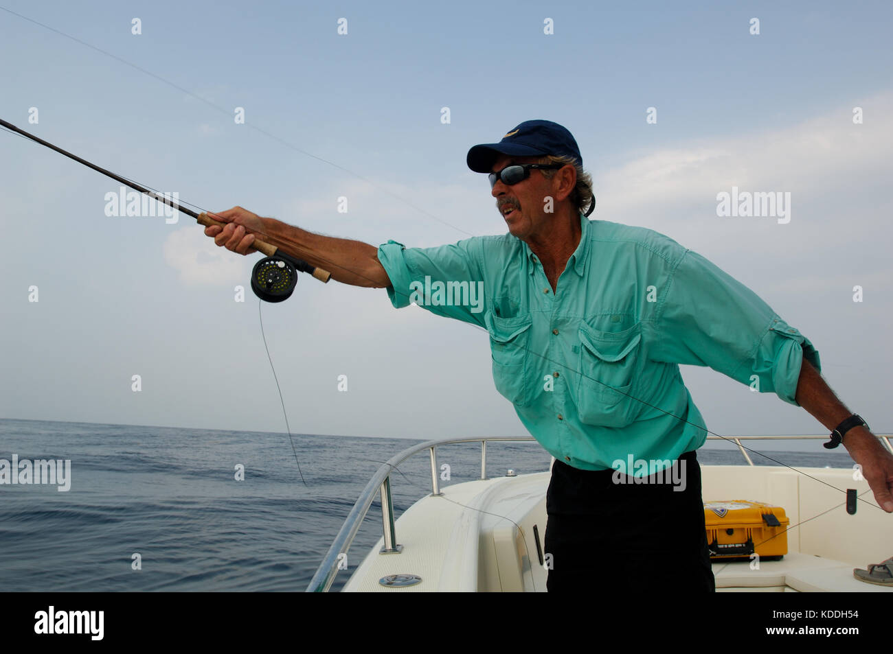 Un pescatore a mosca la colata la sua canna da mosca e cercando kingfish su una linea di erbaccia da offshore Freeport Texas Foto Stock