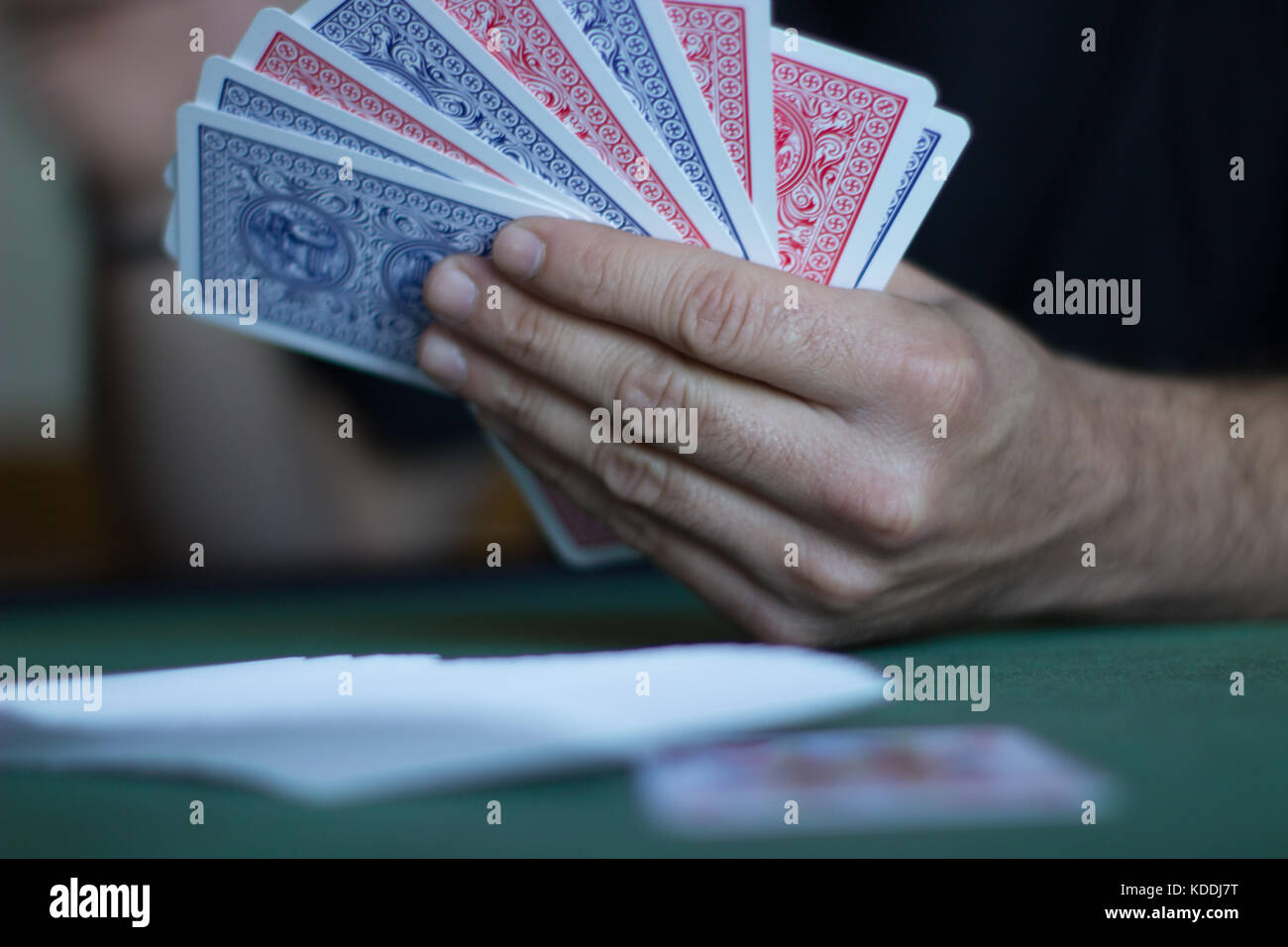 L'uomo la riproduzione di gioco di carte e schede di contenimento close up su un tappeto verde Foto Stock