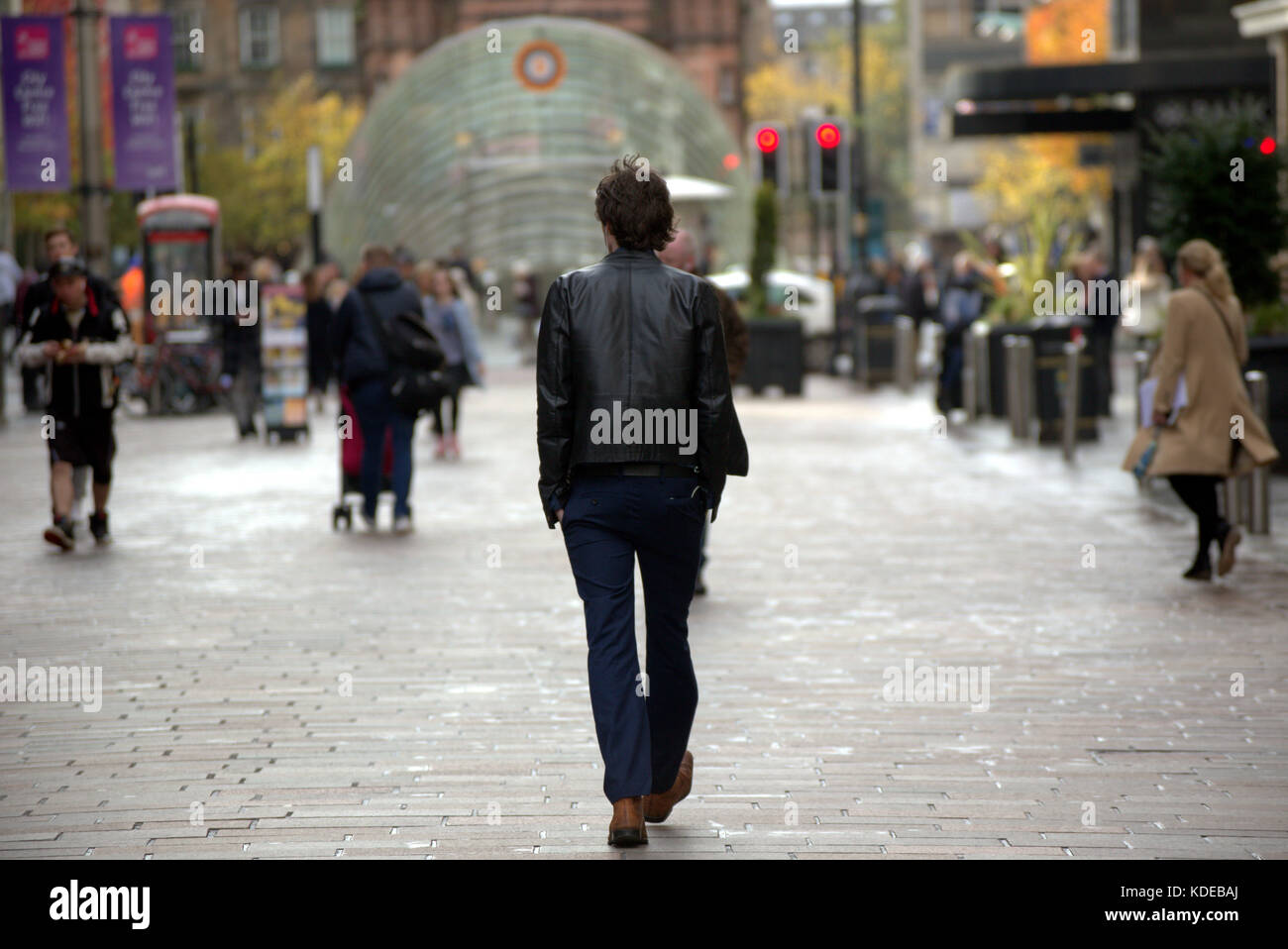 L'uomo maschio giacca di pelle con atteggiamento fiducioso buchanan street style mile glasgow in prospettiva vista da dietro Foto Stock