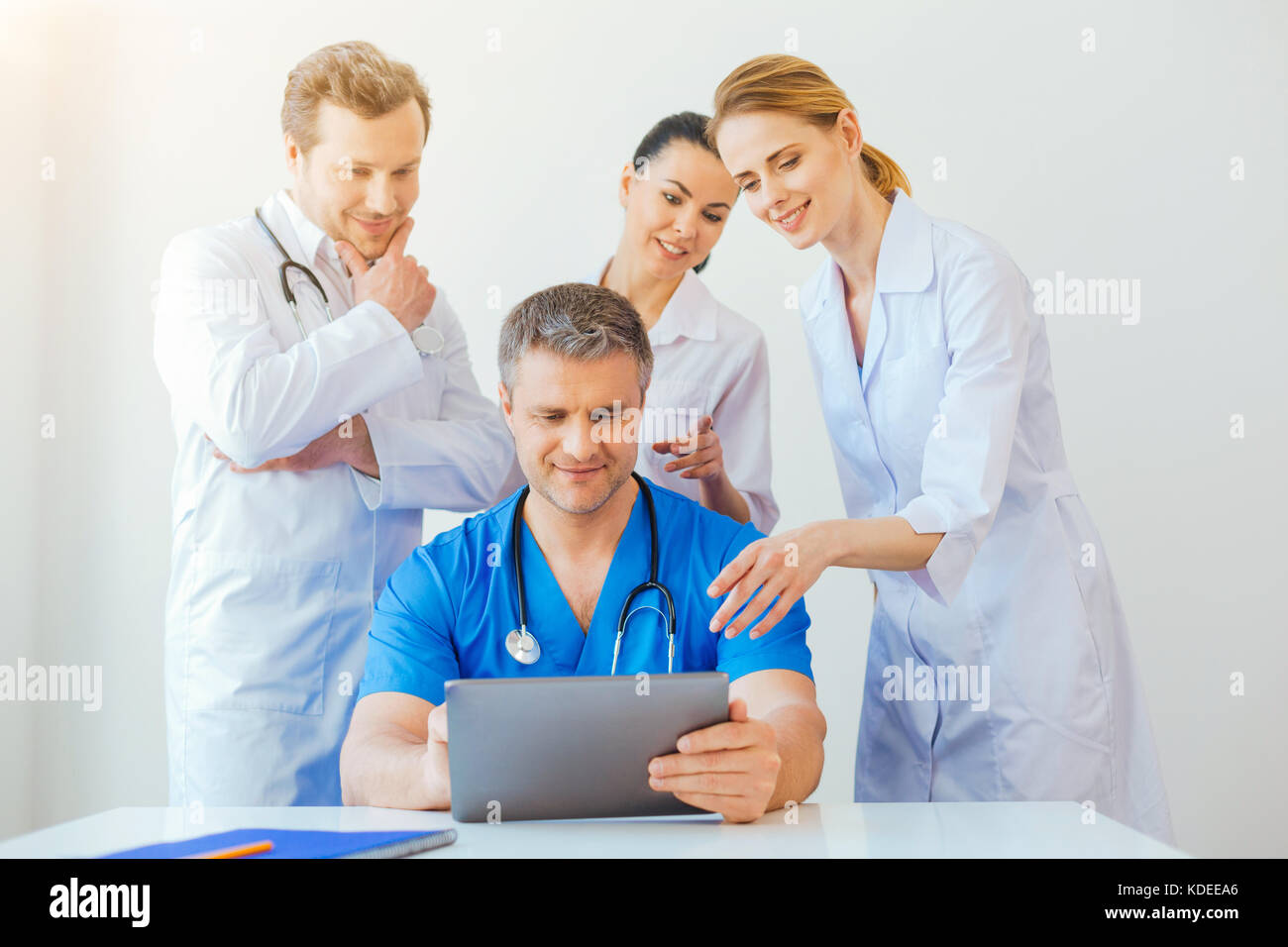 Gentile professionista medico guardando il laptop e sorridente Foto Stock