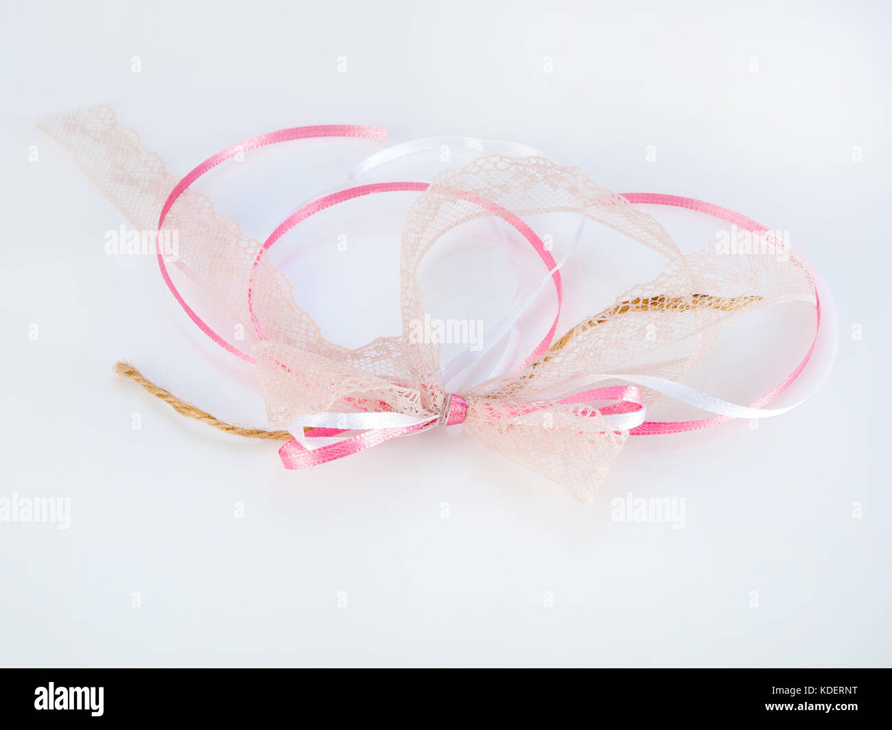 Girly, femminile vintage bianco e rosa con nastri di prua, beige e pizzo stringa, isolati su sfondo bianco Foto Stock