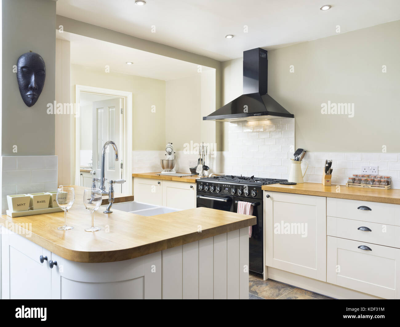 Un nuovo e moderno, crema, shaker in stile designer che mostra la cucina armadi, apparecchi e bancone. Foto Stock