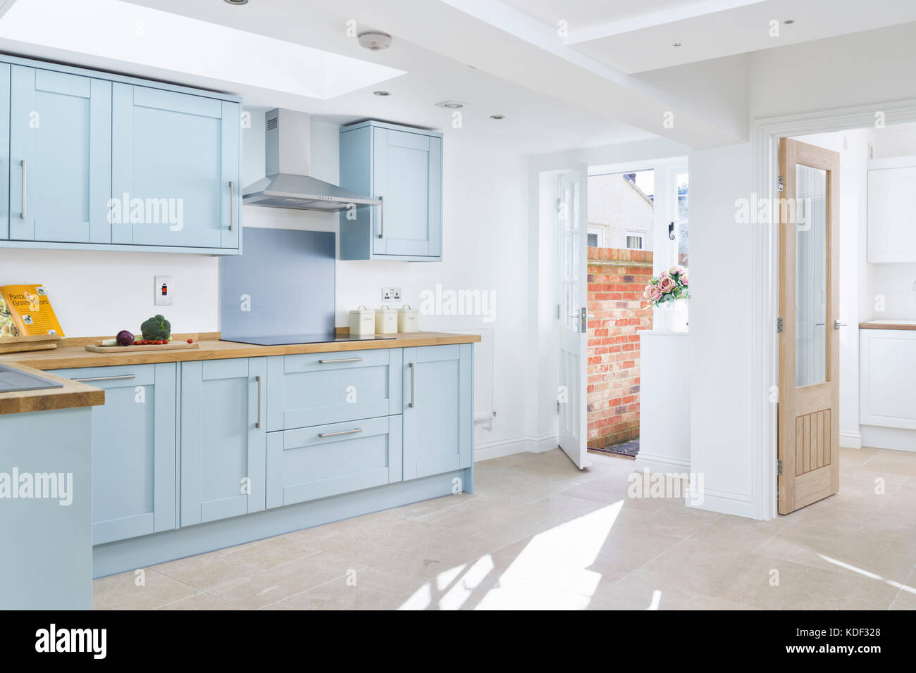 Un nuovo e moderno, blu, shaker in stile designer che mostra la cucina armadi, apparecchi e bancone. in una casa ristrutturata. Foto Stock