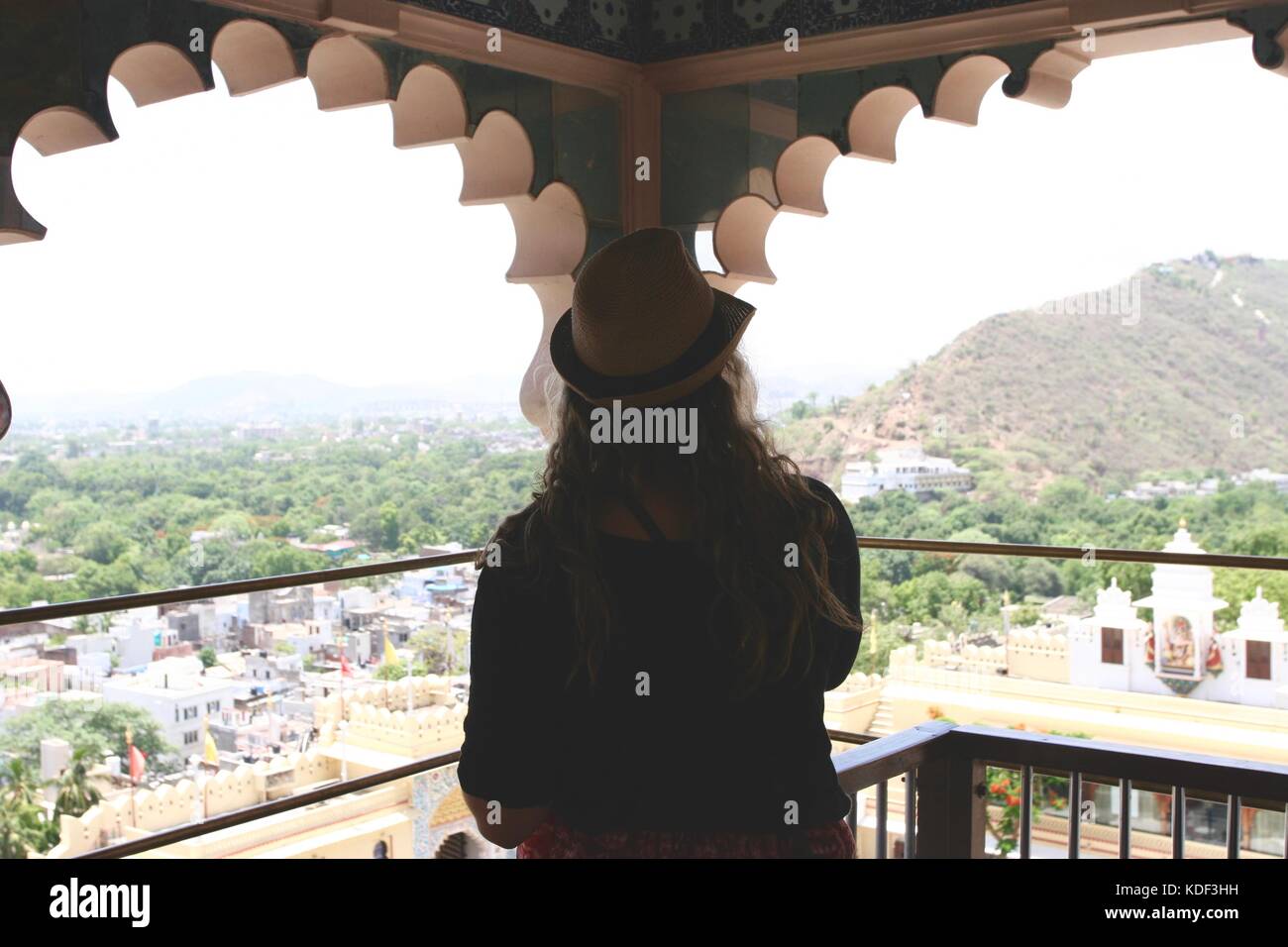 Viaggiatore femmina guarda attraverso una finestra a Udaipur City Palace di Udaipur, India Foto Stock