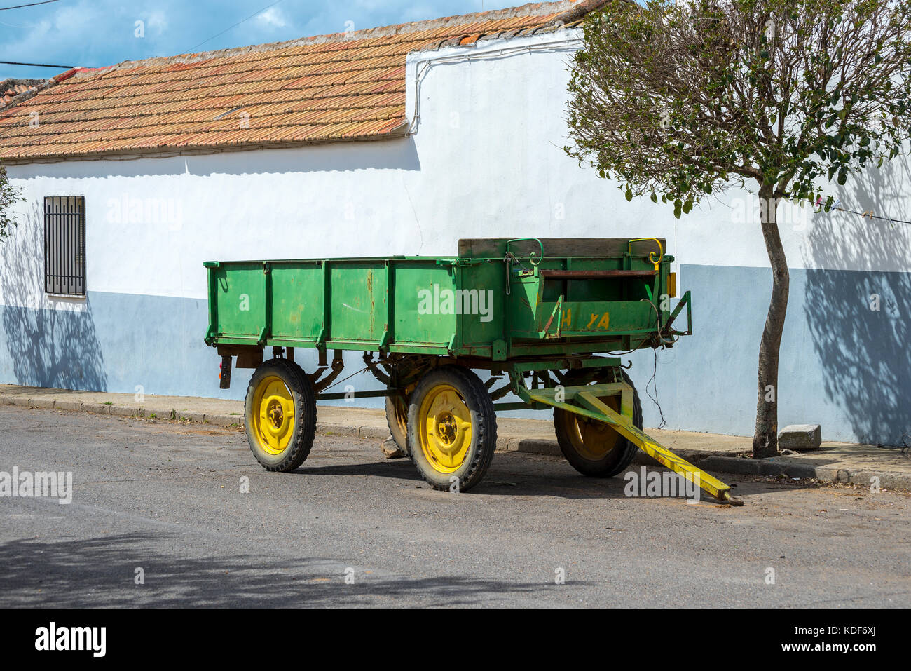 Vecchia fattoria il rimorchio parcheggiato in strada in un piccolo borgo di La Mancha, provincia di Ciudad Real, Spagna Foto Stock