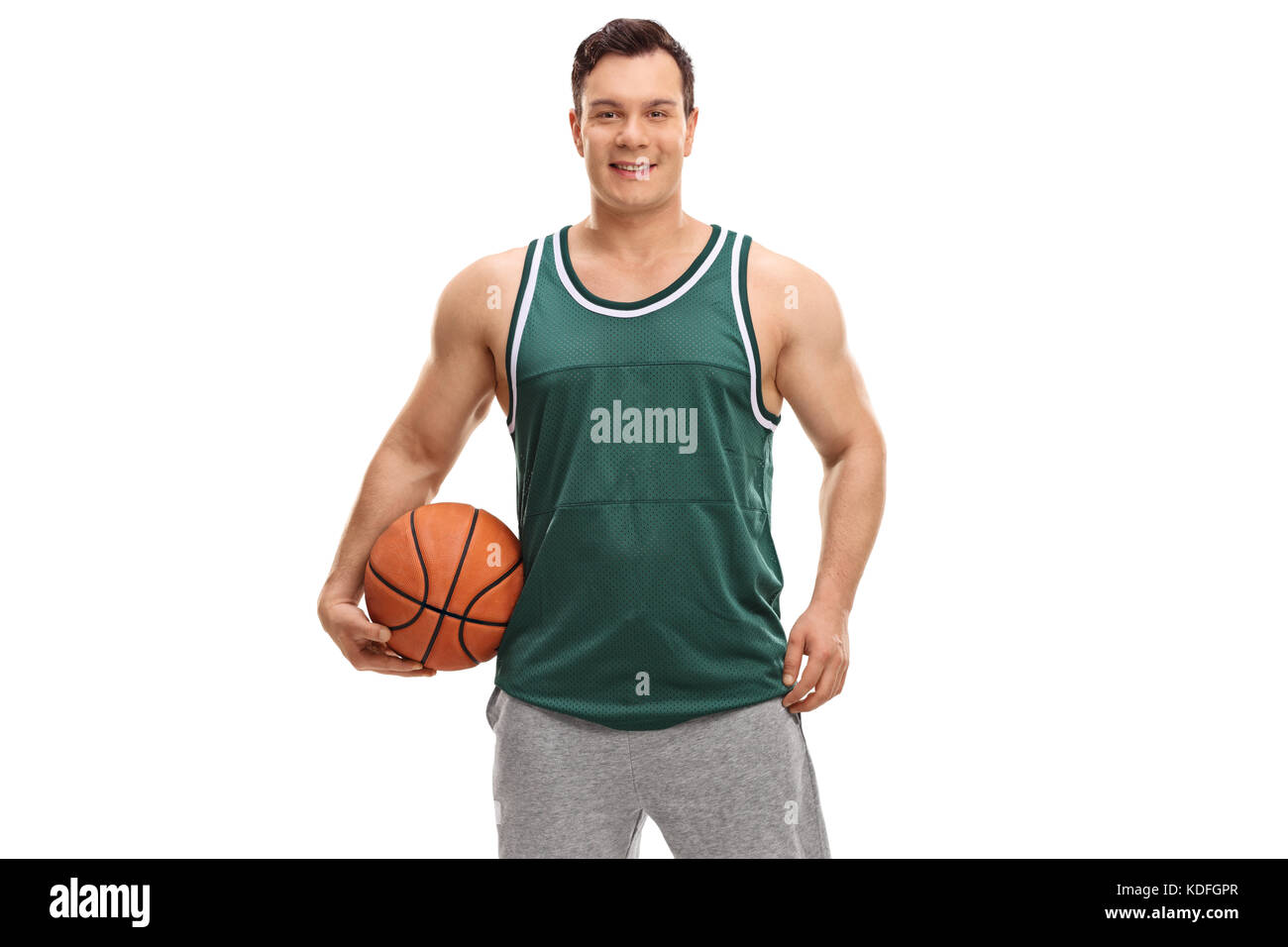 Giovane uomo vestito con una maglia verde in possesso di un basket isolato su sfondo bianco Foto Stock